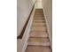 Carpeted staircase with a wooden handrail that leads to upper floor at 8265 Village Pl, Suwanee, GA 30024