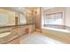 Bathroom featuring dual sinks, a shower with glass doors, and a soaking tub at 915 Chipley Ct, Marietta, GA 30062