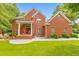 Stunning red brick home featuring a manicured lawn and inviting front porch with stately columns at 915 Chipley Ct, Marietta, GA 30062