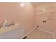 Functional laundry room with tile floor, utility sink, and storage shelves at 915 Chipley Ct, Marietta, GA 30062