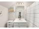 Bright bathroom featuring white vanity, framed mirror and shower with modern striped curtain at 1590 Ridgebrook Downs, Mableton, GA 30126