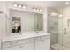 Bathroom featuring double sinks, framed mirror and glass enclosed shower with tile surround at 1590 Ridgebrook Downs, Mableton, GA 30126