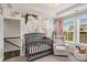 Cozy Bedroom featuring a crib, glider chair, and whimsical wallpaper at 1590 Ridgebrook Downs, Mableton, GA 30126