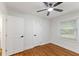 A simple bedroom with a ceiling fan, hardwood floors, and neutral walls at 1927 Willa Way, Decatur, GA 30032