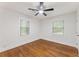 A minimalist bedroom with hardwood floors, light walls, and a ceiling fan at 1927 Willa Way, Decatur, GA 30032