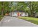 Inviting home with a freshly paved driveway and an orange front door, surrounded by mature trees at 1927 Willa Way, Decatur, GA 30032