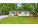 Charming home featuring a freshly painted exterior, neat landscaping, and a bright orange front door at 1927 Willa Way, Decatur, GA 30032