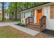 A welcoming front porch features a freshly painted exterior, a vibrant orange door, and professionally done landscaping at 1927 Willa Way, Decatur, GA 30032