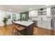 A modern kitchen with white countertops, a grey island with seating, and stainless steel appliances at 1927 Willa Way, Decatur, GA 30032