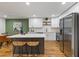 Open-concept kitchen with stainless steel appliances, white cabinetry, hardwood floors, and a dining area at 1927 Willa Way, Decatur, GA 30032