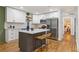 Bright kitchen features white cabinets, stainless steel appliances, an island with seating, and wood flooring at 1927 Willa Way, Decatur, GA 30032