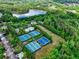 An aerial view reveals tennis courts, a pool, lake, and lush greenery enhancing this community's appeal at 207 Harmony Lake Dr, Canton, GA 30115
