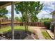Landscaped backyard featuring a well-maintained lawn, brick pathway, wooden fence and a young tree at 207 Harmony Lake Dr, Canton, GA 30115