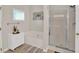 Bright bathroom featuring a bathtub and glass enclosed shower at 207 Harmony Lake Dr, Canton, GA 30115