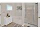 Cozy bathroom featuring bathtub, glass enclosed shower, and neutral paint at 207 Harmony Lake Dr, Canton, GA 30115