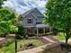Attractive two-story home featuring a metal roof, blue siding, and a beautifully landscaped front yard at 207 Harmony Lake Dr, Canton, GA 30115