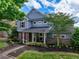 Charming home featuring stone accents, blue siding, manicured landscaping, and a welcoming covered front porch at 207 Harmony Lake Dr, Canton, GA 30115