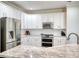 Modern kitchen features stainless appliances, granite counters, tile backsplash, and white cabinets at 207 Harmony Lake Dr, Canton, GA 30115