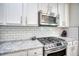 Updated kitchen features granite countertops, stainless gas range and white cabinets at 207 Harmony Lake Dr, Canton, GA 30115