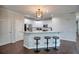 Kitchen features a breakfast bar with seating, stainless steel appliances, white cabinets, and granite countertops at 207 Harmony Lake Dr, Canton, GA 30115