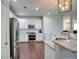 Well-lit kitchen with stainless steel appliances, white cabinets, granite countertops, and hardwood floors at 207 Harmony Lake Dr, Canton, GA 30115