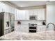 Kitchen features stainless steel appliances, white cabinets, granite countertops, and subway tile backsplash at 207 Harmony Lake Dr, Canton, GA 30115
