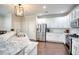 Bright kitchen features granite countertops, stainless steel appliances, white cabinets, and a stylish pendant light fixture at 207 Harmony Lake Dr, Canton, GA 30115