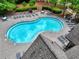 Community swimming pool surrounded by lush landscaping, lounge chairs, and shaded tables at 207 Harmony Lake Dr, Canton, GA 30115