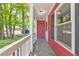 Covered front porch area with red siding, white railing, and black shutters, offering a quaint outdoor space at 350 Pleasant Oak Sw Ct, Marietta, GA 30008