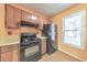 Traditional-style kitchen with gas range, wooden cabinets, black refrigerator and window view at 350 Pleasant Oak Sw Ct, Marietta, GA 30008