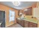 Traditional-style kitchen with wooden cabinets, double sink, window view, and vintage light fixture at 350 Pleasant Oak Sw Ct, Marietta, GA 30008