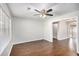 Bright living room featuring wood flooring, a modern ceiling fan, and a large window at 1602 Sycamore Nw Dr, Kennesaw, GA 30152