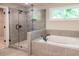 Bathroom with glass enclosed shower and separate soaking tub, tiled with grey stone at 2462 Adair Ridge Ct, Decatur, GA 30034