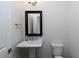 Cozy powder room includes pedestal sink, framed mirror, and modern lighting fixture at 3394 Bryerstone Se Cir, Smyrna, GA 30080