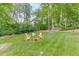 Lush backyard featuring a seating area with manicured lawn and mature trees at 4355 Old Hamilton Mill Rd, Buford, GA 30518