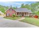 Charming brick home featuring a welcoming front porch, manicured lawn and mature trees at 4355 Old Hamilton Mill Rd, Buford, GA 30518