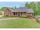 Inviting brick home with a classic front porch, manicured lawn, and mature landscaping at 4355 Old Hamilton Mill Rd, Buford, GA 30518