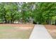 Long driveway leads to a charming home surrounded by lush greenery and landscaping at 4355 Old Hamilton Mill Rd, Buford, GA 30518