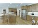 Open kitchen with an island, stainless steel fridge and hardwood floors and custom cabinetry at 4355 Old Hamilton Mill Rd, Buford, GA 30518