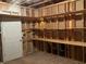 Unfinished basement features built-in shelving and a door leading to other parts of the home at 4567 Brigade Ne Ct, Roswell, GA 30075