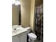 Standard bathroom with a shower-tub combination, toilet, sink, and neutral tan colored walls at 4567 Brigade Ne Ct, Roswell, GA 30075