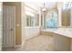 An elegant bathroom featuring dual vanities, a soaking tub, and ornate light fixtures, offering a luxurious spa-like experience at 4567 Brigade Ne Ct, Roswell, GA 30075