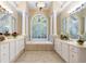 Bright bathroom featuring double vanity, soaking tub under leaded glass window and decorative light fixture at 4567 Brigade Ne Ct, Roswell, GA 30075
