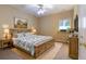 A well-lit bedroom with a wooden bed frame, carpet, and a window at 4567 Brigade Ne Ct, Roswell, GA 30075