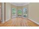 A bright room with three large windows, neutral walls, hardwood floors, and architectural detailing at 4567 Brigade Ne Ct, Roswell, GA 30075