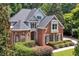 Attractive two-story home featuring a brick facade, dormer windows, and mature landscaping at 4567 Brigade Ne Ct, Roswell, GA 30075