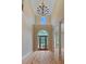 A well-lit foyer with a chandelier, hardwood floors, and a decorative glass door at 4567 Brigade Ne Ct, Roswell, GA 30075