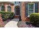 Charming front entrance featuring a brick facade, manicured bushes and an arched doorway at 4567 Brigade Ne Ct, Roswell, GA 30075