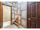 Hallway with unique stone textured wall leading to staircase and doorway revealing tiled flooring at 4567 Brigade Ne Ct, Roswell, GA 30075