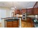 Well-equipped kitchen featuring wooden cabinetry, granite countertops, stainless steel appliances, and decorative lighting at 4567 Brigade Ne Ct, Roswell, GA 30075